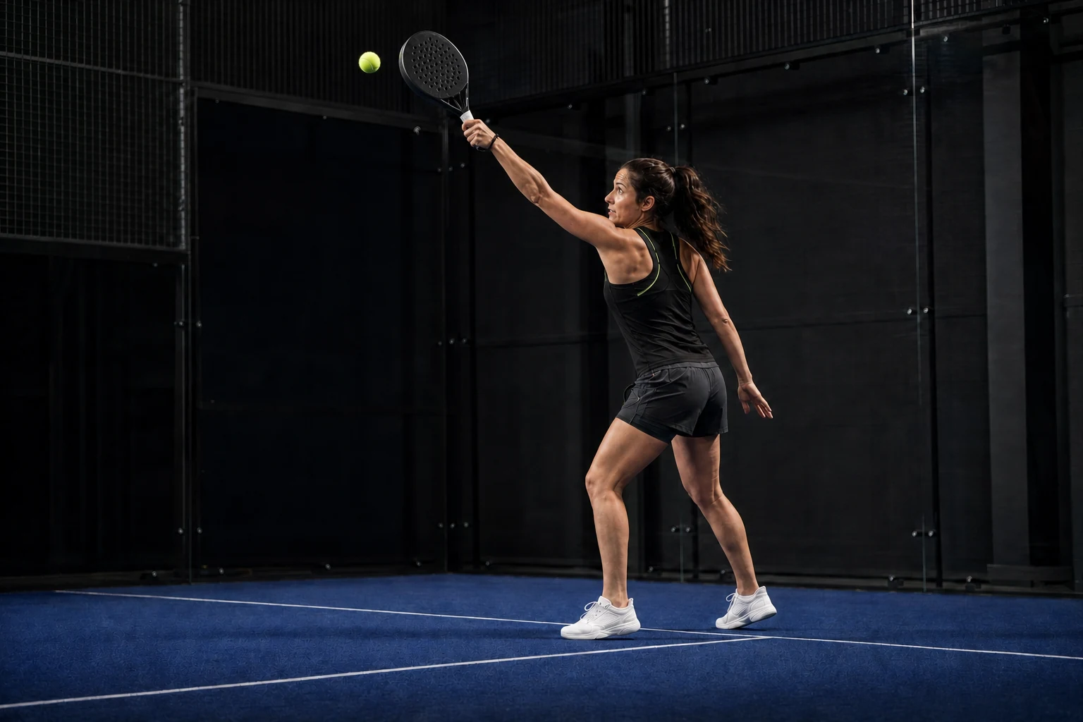 Rechtshändige Padel-Spielerin beim seitlichen Treffpunkt einer Vorhand-Bandeja