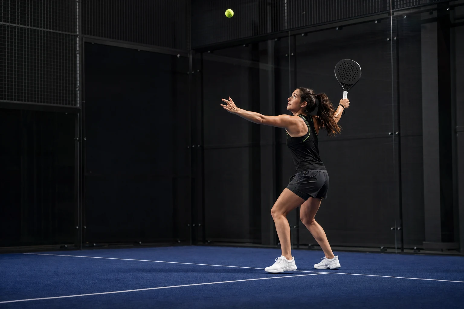 Rechtshändige Padel-Spielerin in früher Vorhand-Bandeja-Vorbereitung mit Blick zum ankommenden Lob