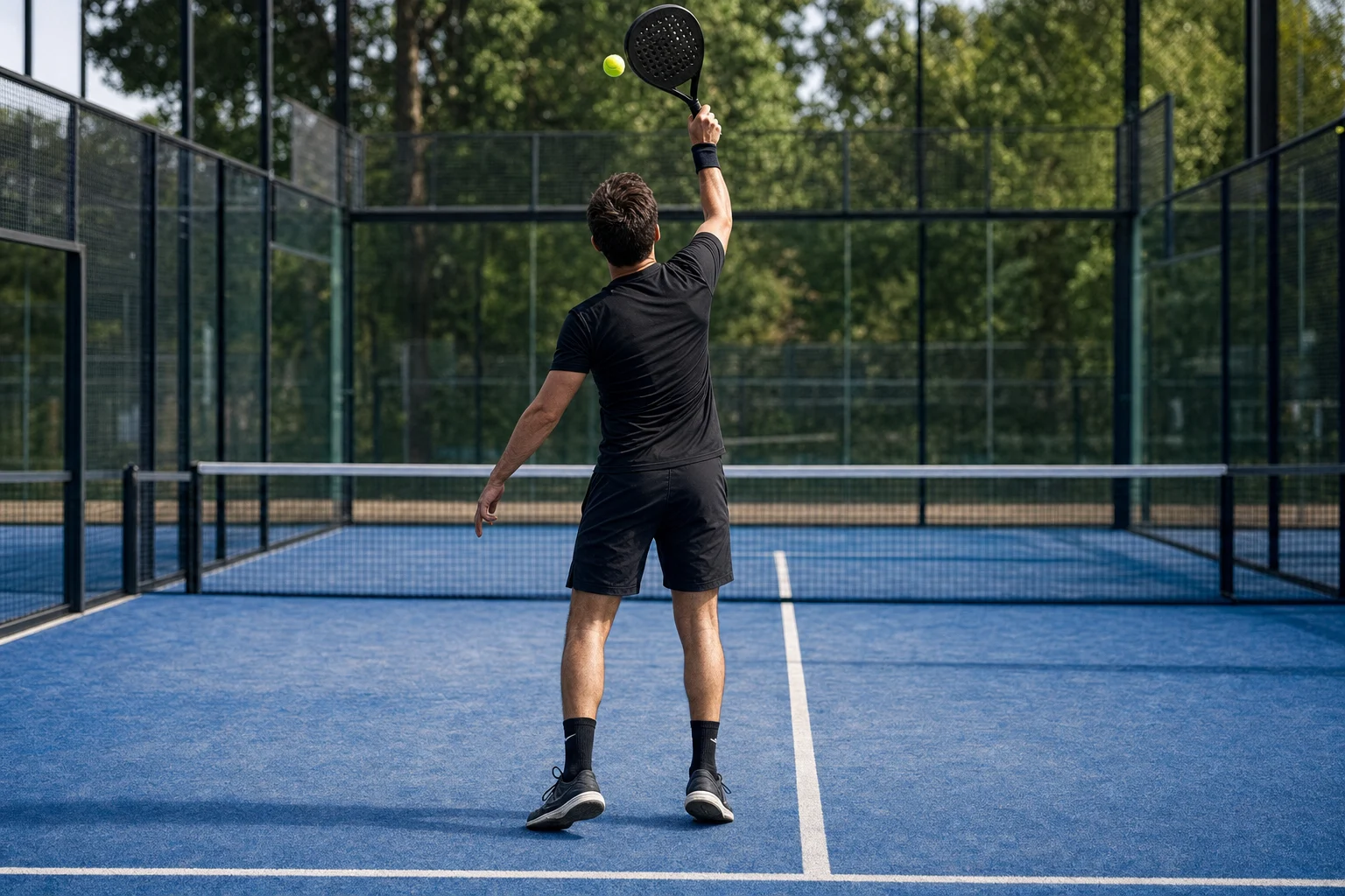 Rechtshändiger Padel-Spieler am hohen Kicksmash-Treffpunkt mit Ball leicht links über dem Kopf